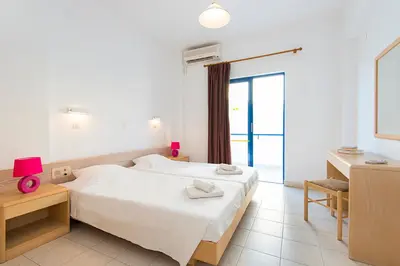 a bedroom with a bed and a desk and a window at Blue Roses in Ixia