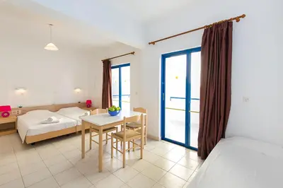 a bedroom with a bed and a table and a bed at Blue Roses in Ixia