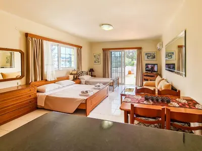 a living room with a bed and a table at Colonial Studio/Apartment in Faliraki