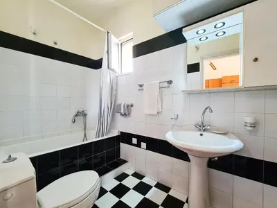 a bathroom with a white toilet and a sink at Colonial Studio/Apartment in Faliraki