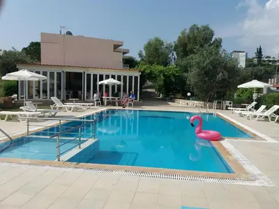 a swimming pool with a pink swan in the middle at Colonial Studio/Apartment in Faliraki