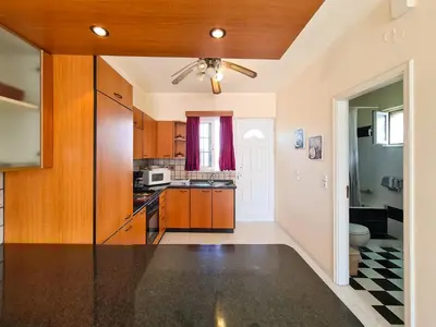 a kitchen with wooden cabinets and a ceiling at Colonial Studio/Apartment in Faliraki