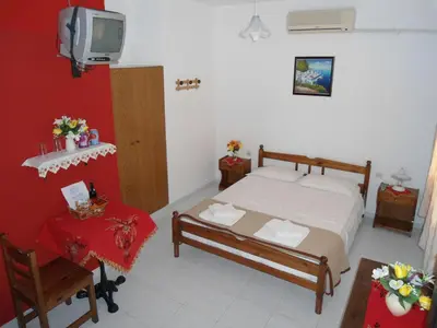 a bedroom with a bed and a tv and a table at Evi Apartments And Studios in Theologos