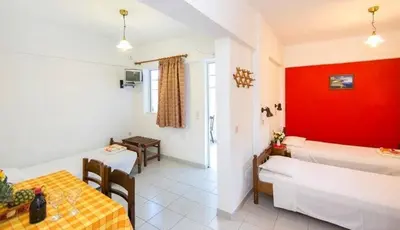 a room with a bed and a table and chairs at Evi Apartments And Studios in Theologos