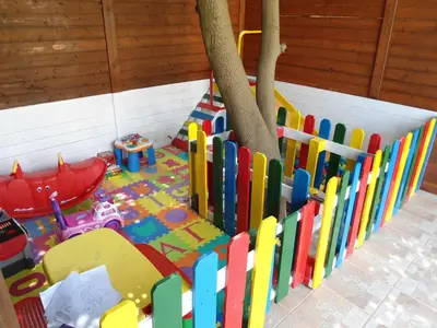 a childrens play area with a wooden fence at Evi Apartments And Studios in Theologos