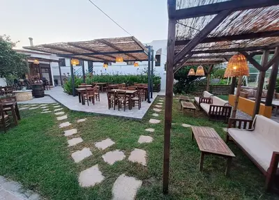 a patio with tables and chairs under a pergola at Evi Apartments And Studios in Theologos