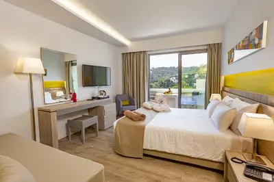 a hotel room with a bed and a desk at Akti Imperial Deluxe Resort & Spa Dolce by Wyndham in Ixia