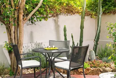 a patio table and chairs in a garden at AQUAMARE CITY and BEACH in Rhodes Town