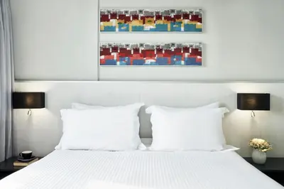 a bedroom with a white bed with two white pillows at AQUAMARE CITY and BEACH in Rhodes Town