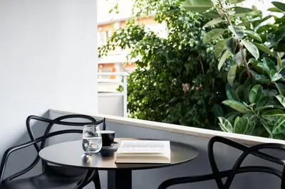 a table and chairs with a book and a glass at AQUAMARE CITY and BEACH in Rhodes Town