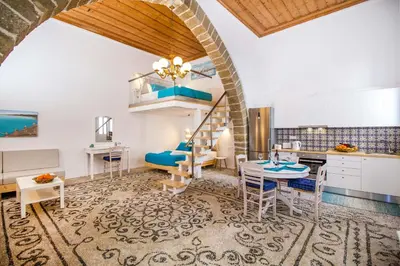 a kitchen and living room with a loft bed and a table at The red door in Koskinou in Koskinou
