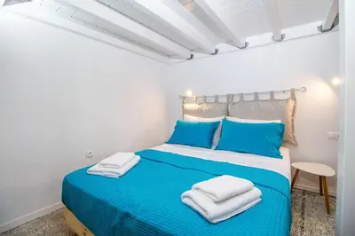 a bedroom with a blue bed with towels on it at The red door in Koskinou in Koskinou