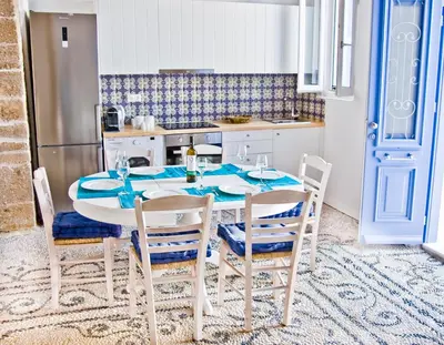a dining room with a table and chairs in a kitchen at The red door in Koskinou in Koskinou