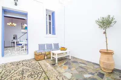 a living room with a table and a vase with a plant at The red door in Koskinou in Koskinou