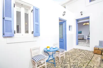 a patio with a table and chairs and a door at The red door in Koskinou in Koskinou