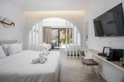 a bedroom with a bed and a desk with a tv at Aiora Aqua Resort in Pefki Rhodes