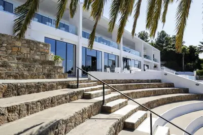 a building with stairs and palm trees in front of it at Aiora Aqua Resort in Pefki Rhodes