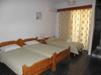 a bedroom with two beds and a window at Afroditi Pension in Archangelos