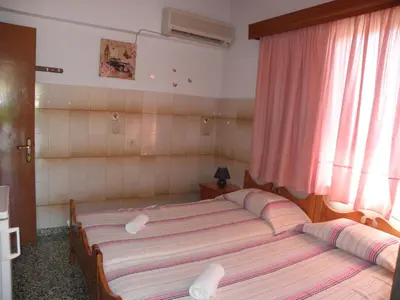 a bedroom with a bed with two pillows on it at Afroditi Pension in Archangelos