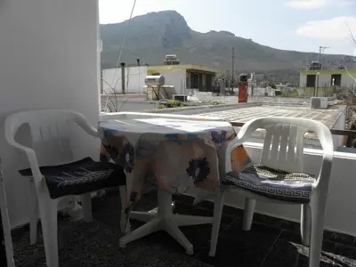 two chairs and a table with a table cloth on a balcony at Afroditi Pension in Archangelos