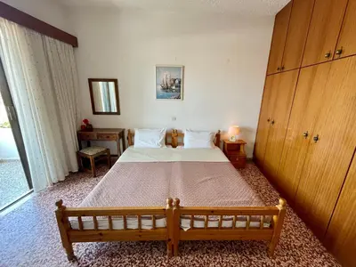 a bedroom with a large bed and a large window at Afroditi Pension in Archangelos