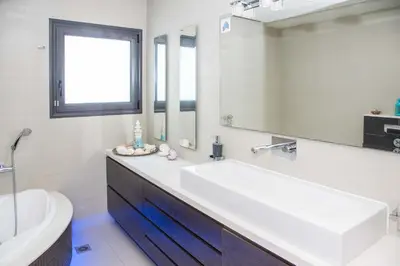 a bathroom with a sink and a toilet and a mirror at Villa Elena in Triánta