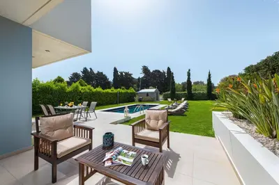 a patio with chairs and a table and a pool at Villa Elena in Triánta