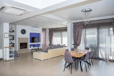 a dining room and living room with a table and chairs at Villa Elena in Triánta