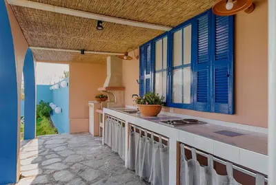 a kitchen with blue windows and a counter top at Afandou Beach Villas Sofias in Afantou