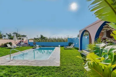 a backyard with a swimming pool and grass at Afandou Beach Villas Sofias in Afantou