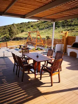 a wooden table and chairs on a patio at Villa Dimitrios in Kiotari