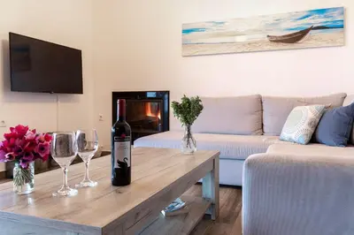 a living room with a bottle of wine on a table at Villa Dimitrios in Kiotari