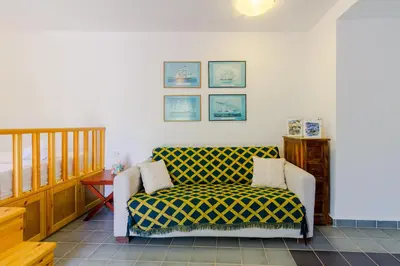 a living room with a couch and a chair at The Vegghera House in Symi