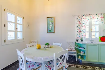a kitchen with a table and chairs and a sink at The Vegghera House in Symi