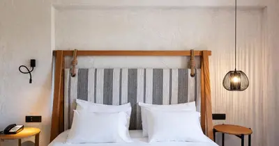 a bedroom with a bed with two white pillows at Pedi Beach Hotel in Symi