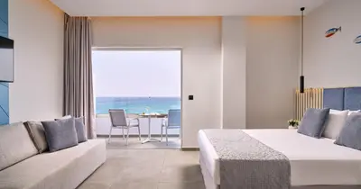 a bedroom with a bed and a couch and a table at Blue Sea Beach Resort in Faliraki