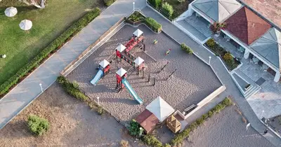 an overhead view of a playground with tables and umbrellas at Blue Sea Beach Resort in Faliraki