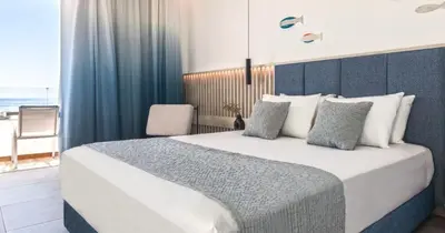a bedroom with a large bed with a view of the ocean at Blue Sea Beach Resort in Faliraki