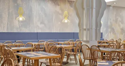 a group of tables and chairs in a restaurant at Blue Sea Beach Resort in Faliraki