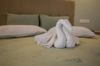 a white towel animal sitting on top of a bed at Maroula Studios in Faliraki