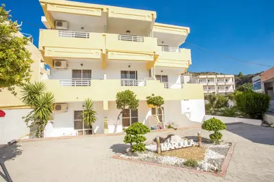 a large white building with trees in front of it at Maroula Studios in Faliraki