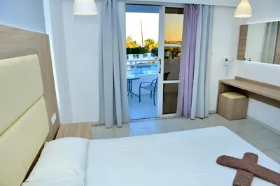 a bedroom with a bed with a teddy bear on it at Maroula Studios in Faliraki