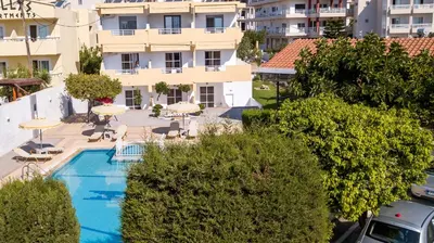 an overhead view of a swimming pool with umbrellas and a building at Maroula Studios in Faliraki