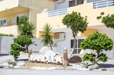 a sign in front of a building with trees at Maroula Studios in Faliraki