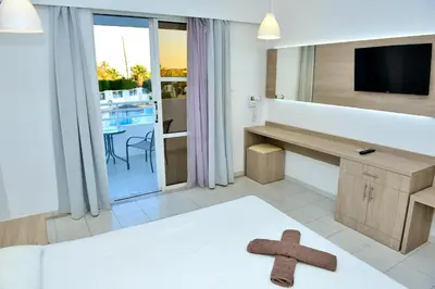 a hotel room with a cross on the bed at Maroula Studios in Faliraki