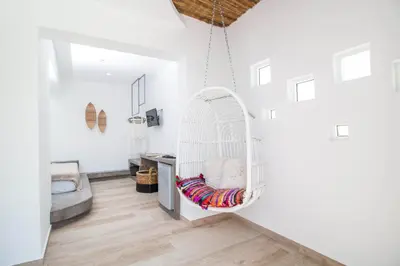 a white room with a swing hanging from the wall at Malibu Boutique Studios & Bungalows in Faliraki