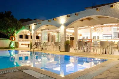 a villa with a swimming pool at night at Malibu Boutique Studios & Bungalows in Faliraki