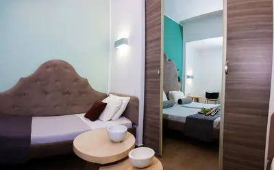 a small room with two beds and a mirror at Malibu Boutique Studios & Bungalows in Faliraki