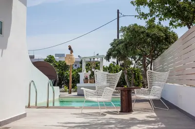 a group of chairs and a table on a patio at Malibu Boutique Studios & Bungalows in Faliraki