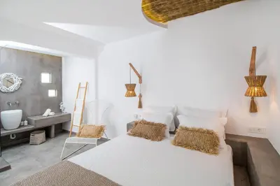 a white bedroom with a large bed and a sink at Malibu Boutique Studios & Bungalows in Faliraki